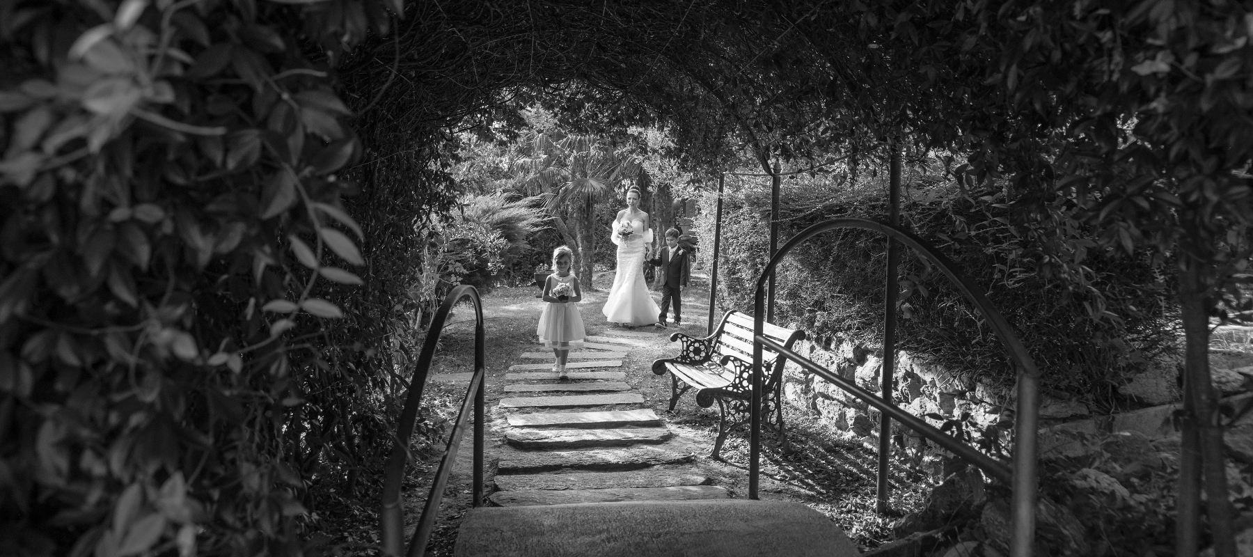 Matrimonio-Sposa-Altare-Ritratto-Ambientato Foto del matrimonio di Paola e Fabio mentre la sposa sta per passare sotto al pergolato assieme ai figli
